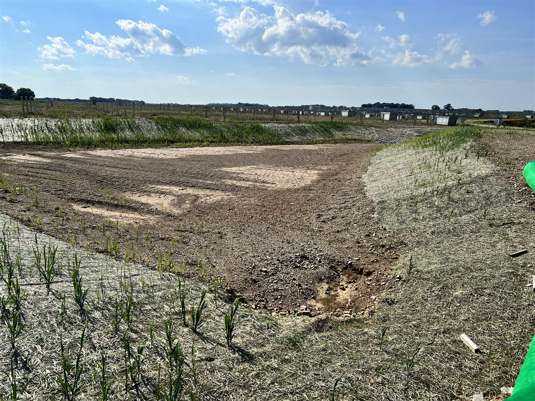 Retention pond with curlex erosion blanket, straw wattle, and riprap outlet at a utility-scale solar site